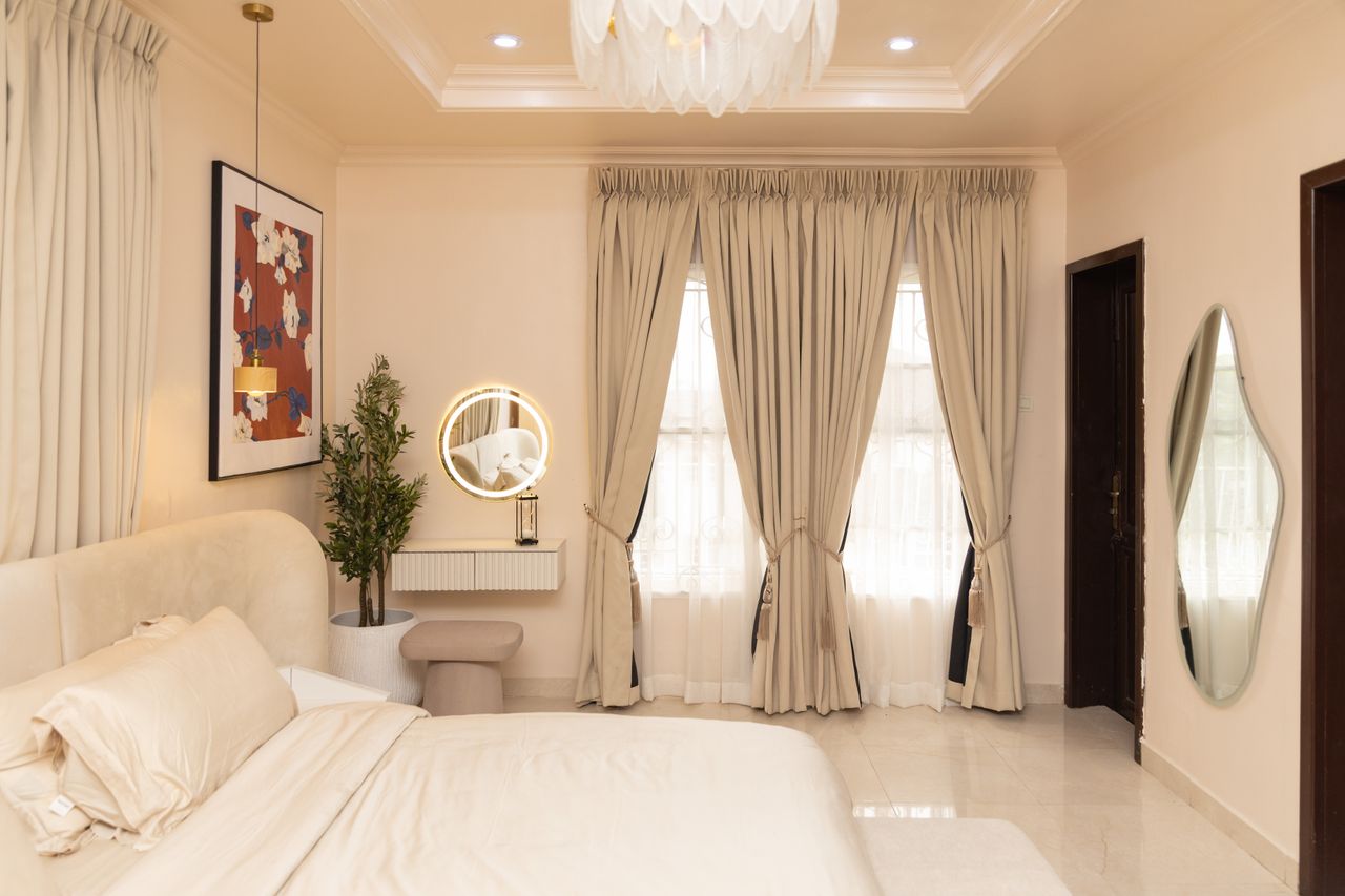 Stylish bedroom with beige decor, soft lighting, and modern furnishings.